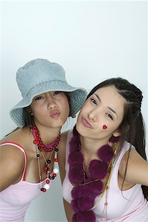 Two young female friends wearing lots of accessories, puckering at camera, portrait Stock Photo - Premium Royalty-Free, Code: 696-03394630