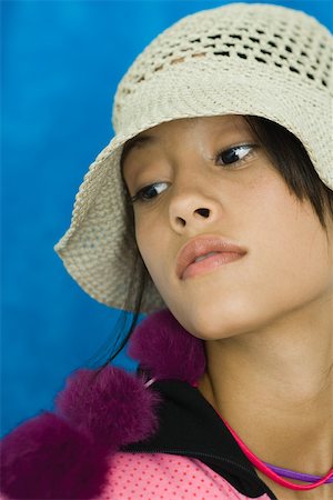Teenage girl wearing hat, looking away, portrait Stock Photo - Premium Royalty-Free, Code: 696-03395004