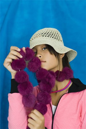 Teenage girl wearing hat, holding boa against face, portrait Stock Photo - Premium Royalty-Free, Code: 696-03395000