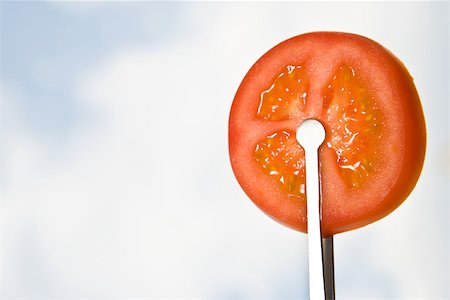 Tongs holding up tomato slice, close-up Stock Photo - Premium Royalty-Free, Code: 696-03395626