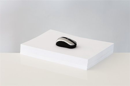 Computer mouse on top of stack of paper Stock Photo - Premium Royalty-Free, Code: 696-03395971