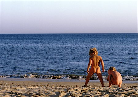 Des enfants nus, jouant sur la plage, arrière vue Photographie de stock - Premium Libres de Droits, Code: 696-03397544