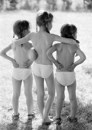 Three small girls standing outside in underwear, rear view, b&w Stock Photo - Premium Royalty-Free, Code: 696-03398682