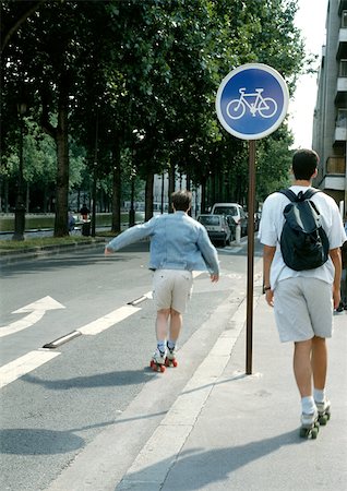 roller skate - Two people roller-skating, one on bike lane Stock Photo - Premium Royalty-Free, Code: 696-03398834