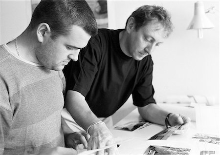 Two men looking at documents on desk, b&w Stock Photo - Premium Royalty-Free, Code: 696-03398869