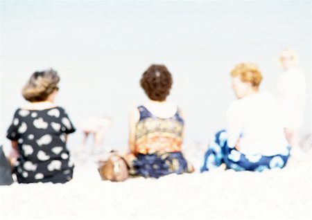 simsearch:696-03399615,k - People sitting on sand at the beach, rear view, blurred Stock Photo - Premium Royalty-Free, Code: 696-03399602