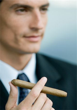Businessman holding cigar Stock Photo - Premium Royalty-Free, Code: 696-03400254