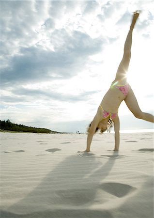 simsearch:633-01714467,k - Girl doing cartwheel on beach Stock Photo - Premium Royalty-Free, Code: 696-03401201