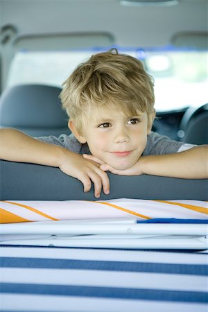 Boy in car, looking over back of seat Stock Photo - Premium Royalty-Free, Code: 696-03401544