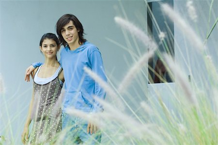 simsearch:633-01715612,k - Young couple, smiling at camera, long grass in foreground Stock Photo - Premium Royalty-Free, Code: 696-03401610