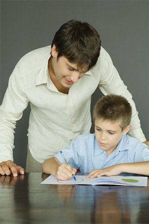photo man space for coloring - Father and son, man looking over boy's shoulder as he colors Stock Photo - Premium Royalty-Free, Code: 696-03401651