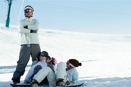 simsearch:696-03401677,k - Snowboarders lying in snow, looking up at friend Stock Photo - Premium Royalty-Free, Code: 696-03401670