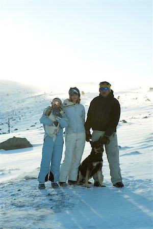 Skieurs debout sur une pente enneigée avec deux chiens Photographie de stock - Premium Libres de Droits, Code: 696-03401671
