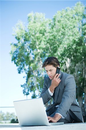 simsearch:400-05366591,k - Businessman using laptop and cell phone, outdoors Stock Photo - Premium Royalty-Free, Code: 696-03401752