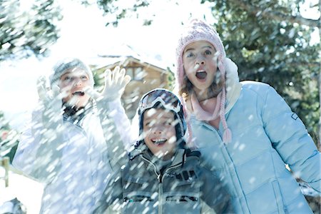 simsearch:400-05697219,k - Young friends standing in falling snow, smiling, waist up Stock Photo - Premium Royalty-Free, Code: 696-03401767