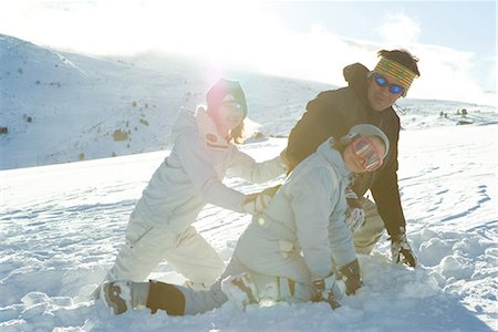 simsearch:632-01156716,k - Père et ses deux filles, accroupi dans la neige, souriant Photographie de stock - Premium Libres de Droits, Code: 696-03401773