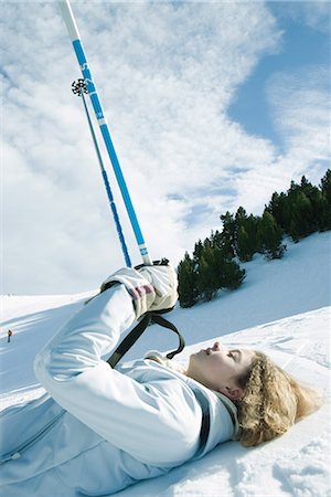 simsearch:695-03376478,k - Young female skier lying on ground, holding up ski sticks, eyes closed Foto de stock - Sin royalties Premium, Código: 696-03401838