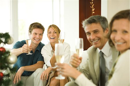 simsearch:693-06435898,k - Adult friends making a toast with champagne, smiling at camera Stock Photo - Premium Royalty-Free, Code: 696-03401852