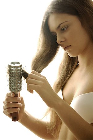 Young woman in bra brushing hair Stock Photo - Premium Royalty-Free, Code: 696-03401931
