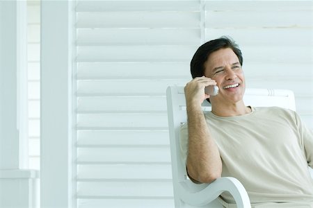 simsearch:695-03376228,k - Man using cell phone on porch, smiling Stock Photo - Premium Royalty-Free, Code: 696-03402139