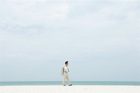 simsearch:632-03500607,k - Man in suit walking along beach, side view Stock Photo - Premium Royalty-Free, Code: 696-03402189