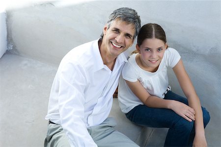 simsearch:695-03378605,k - Father and daughter sitting together, smiling at camera, portrait Stock Photo - Premium Royalty-Free, Code: 696-03402504