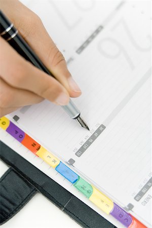 schedule - Person writing in agenda, cropped view of hand Stock Photo - Premium Royalty-Free, Code: 696-03402556