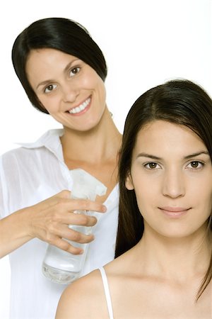 Hair stylist spraying woman's hair, both smiling at camera Stock Photo - Premium Royalty-Free, Code: 696-03402618