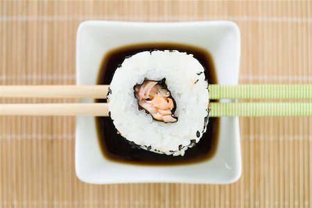 Maki sushi resting on chopsticks above soy sauce, overhead view Foto de stock - Sin royalties Premium, Código: 696-03402781