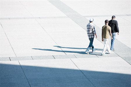 simsearch:696-03399615,k - Young men walking together across public square Stock Photo - Premium Royalty-Free, Code: 696-03402954