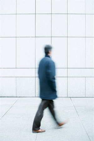 reservation - Man walking with hands in pockets down sidewalk Stock Photo - Premium Royalty-Free, Code: 696-03402967