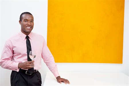 Portrait of smiling young man in front of painting Stock Photo - Premium Royalty-Free, Code: 693-05552766