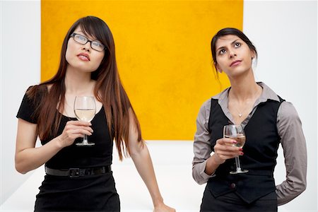 simsearch:693-05552760,k - Front view of young females with wine glass looking up in art gallery Stock Photo - Premium Royalty-Free, Code: 693-05552768
