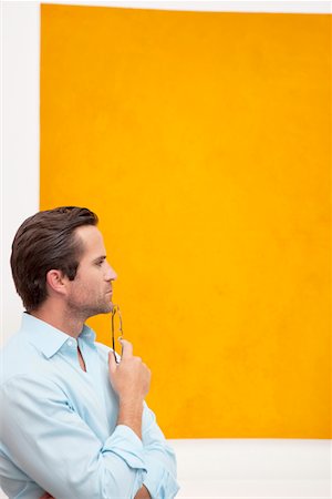 simsearch:693-05552760,k - Close-up view of a thoughtful young man in front of wall painting Stock Photo - Premium Royalty-Free, Code: 693-05552761