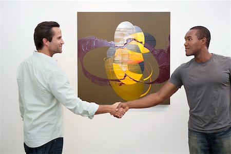 simsearch:693-05552760,k - Two man in casuals shaking hands in front of wall painting Stock Photo - Premium Royalty-Free, Code: 693-05552776