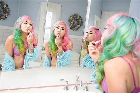 simsearch:693-05552824,k - Young woman applying lipstick on her lips with multiple mirror reflections Stock Photo - Premium Royalty-Free, Code: 693-05552810