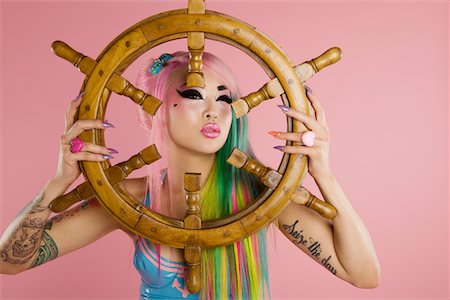 simsearch:693-05552824,k - Young woman holding ship's wheel in front of her face Stock Photo - Premium Royalty-Free, Code: 693-05552835