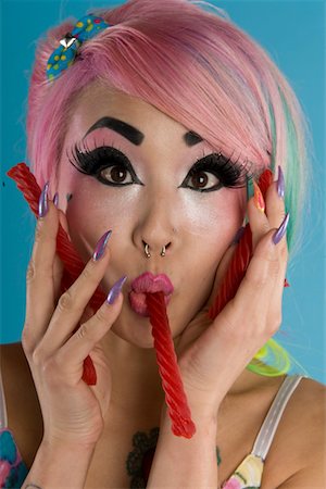 simsearch:693-05552824,k - Portrait of young woman holding candy cane in her mouth Stock Photo - Premium Royalty-Free, Code: 693-05552845