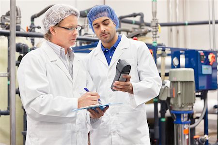 Deux hommes qui travaillaient dans l'usine de mise en bouteille Photographie de stock - Premium Libres de Droits, Code: 693-05794216