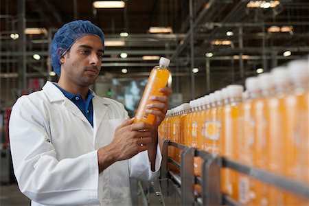 scrutiny - Worker examining orange juice bottle at bottling plant Stock Photo - Premium Royalty-Free, Code: 693-05794230