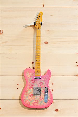 Pink paisley Fender guitar on wood grain wall Stock Photo - Premium Royalty-Free, Code: 693-05794342