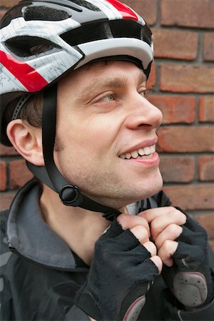 Bicyclist adjusting his helmet Stock Photo - Premium Royalty-Free, Code: 693-05794564