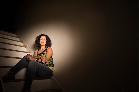 spotlight (beam of light) - Woman sitting on steps in dark Stock Photo - Premium Royalty-Free, Code: 693-05793972
