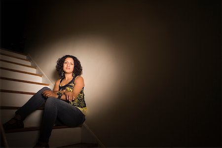 Woman sitting on steps in dark Stock Photo - Premium Royalty-Free, Code: 693-05793972