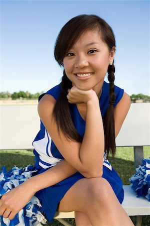 Smiling Cheerleader sitting on bench, (portrait) Stock Photo - Premium Royalty-Free, Code: 693-06014242
