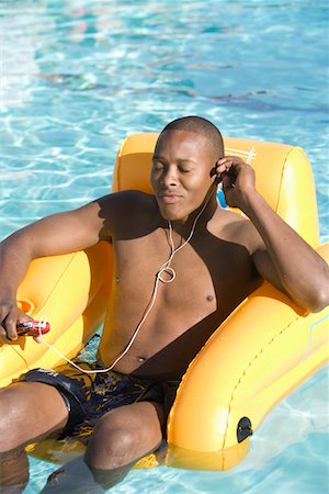 Young Man Listening to Music in Swimming Pool Stock Photo - Premium Royalty-Free, Code: 693-06015297