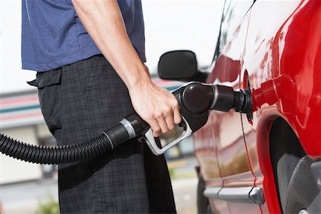 simsearch:6105-05395912,k - Young man filling car with gas at gas station, mid section Stock Photo - Premium Royalty-Free, Code: 693-06015511