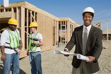 simsearch:693-06016727,k - Two construction workers and surveyor holding blueprint Stock Photo - Premium Royalty-Free, Code: 693-06016749