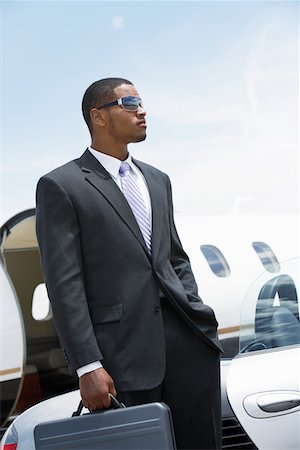 Businessman standing Beside Airplane, hand in pocket, holding a briefcase Stock Photo - Premium Royalty-Free, Code: 693-06016943