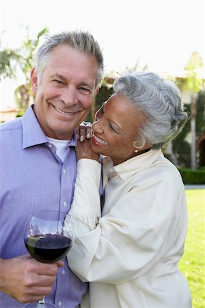 Happy Older Couple, hand on shoulder, standing outside, holding wineglass with red wine Stock Photo - Premium Royalty-Free, Code: 693-06017232